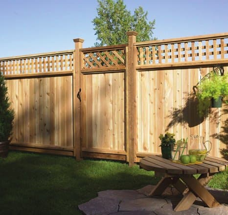 Square lattice-top cedar fence panels installed in a garden