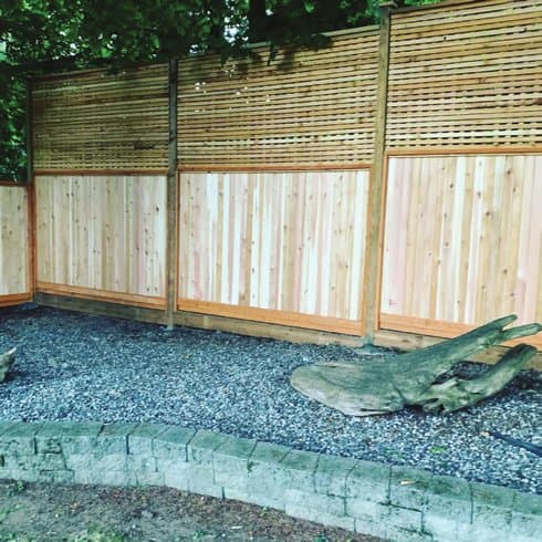 Modern wood and steel fence line installed at dusk